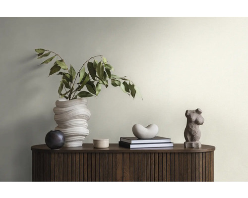 Dekorative Szene mit einer Blumenvase, Skulpturen und Büchern auf einem dunklen Holzschrank.