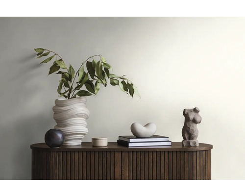 Dekoratives Interieur mit Vase, Büchern und Skulpturen auf einem Holzschrank