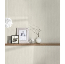Scène avec un papier peint de couleur claire avec un motif vertical, une étagère en bois avec des objets décoratifs tels que des cadres photo et un vase