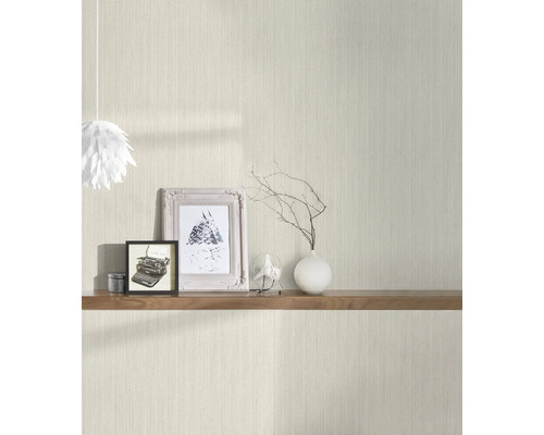 Scène avec un papier peint de couleur claire avec un motif vertical, une étagère en bois avec des objets décoratifs tels que des cadres photo et un vase
