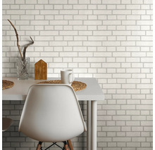 Papier peint à motif de briques derrière une table à manger avec une chaise