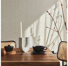 Salle à manger avec table en bois, vaisselle, bougeoir, bougie et papier peint textile