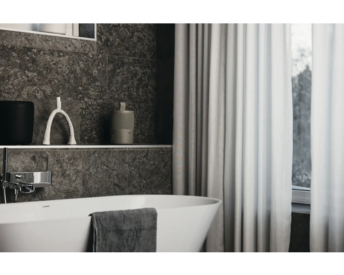Badezimmeransicht mit Badewanne, Vorhang und dekorativen Accessoires