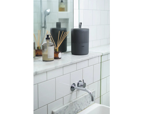 Scène de salle de bains avec diffuseur de parfum et robinet sur le lavabo