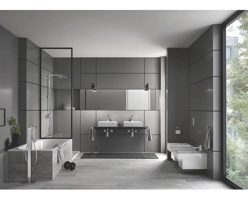 Salle de bains moderne avec baignoire, douche, double vasque et toilettes.