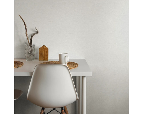 Scène avec table blanche, chaise, tasse et décoration devant un papier peint texturé