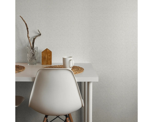 Scène avec table à manger, chaise, décoration et papier peint à motifs.