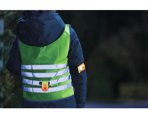 Personne portant un gilet de sécurité et un brassard réfléchissants pour une meilleure visibilité