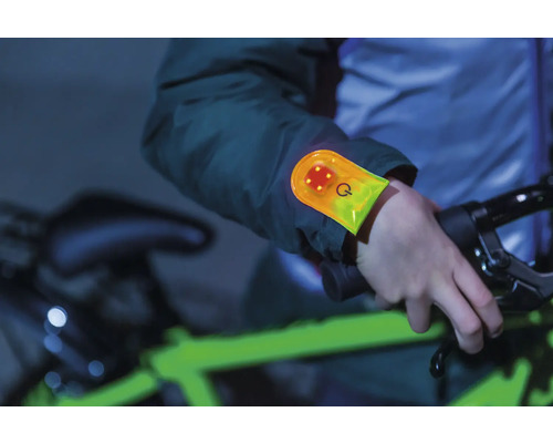 Personne avec bracelet LED faisant du vélo dans l''obscurité pour plus de sécurité