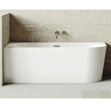 Baignoire rectangulaire en acrylique sanitaire avec robinetterie sur un mur en béton