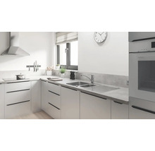 Cuisine moderne avec évier, plaque de cuisson, hotte aspirante et ustensiles de cuisine.