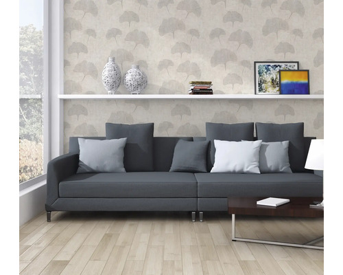 Salon avec canapé gris, bibliothèque et papier peint décoratif à motifs végétaux.