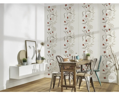 Esszimmer mit floraler Tapete, Holztisch und Stühlen.