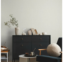 Wohnzimmer mit Kommode, Sessel, Tisch und Dekorationsgegenständen