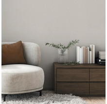 Szene mit Sessel, Kissen, Kommode, Vase und Büchern