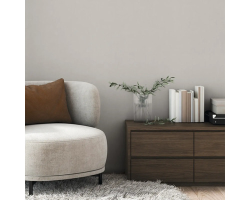 Szene mit Sessel, Kissen, Kommode, Vase und Büchern