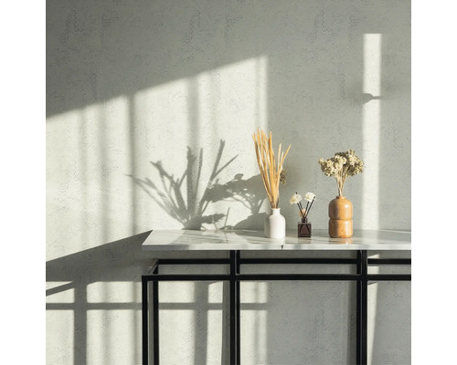 Mur avec motif, table avec décorations comme des vases et des fleurs séchées.