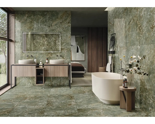 Salle de bain moderne avec carrelage en marbre vert, baignoire îlot et meuble-lavabo avec deux lavabos.