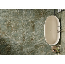 Salle de bains avec baignoire et carrelage vert imitation marbre