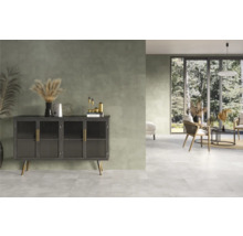 Pièce claire et accueillante avec carrelage, commode et coin salon.