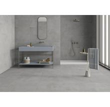 Salle de bain lumineuse avec carrelage gris, lavabo avec miroir et douche