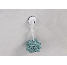 Duschschwamm hängt an einem Saugnapf-Haken an der Wand