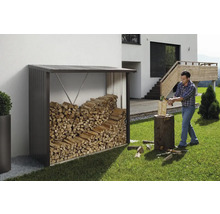 Étagère à bois de chauffage en métal avec bois et homme coupant du bois dans le jardin