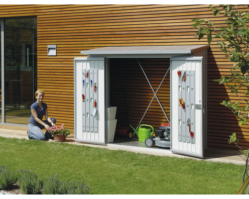 Armoire de jardin avec portes ouvertes, équipée d''outils de jardinage, d''une tondeuse à gazon et d''un arrosoir dans le jardin.