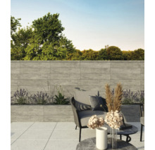 Terrasse mit grauer Steinmauer, Sitzgelegenheiten und Pflanzen