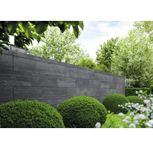 Gartenlandschaft mit Steinmauer und Büschen