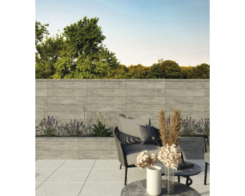 Terrasse avec jardinières et sièges devant un mur de parement de façade