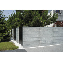 Clôture en béton avec éléments métalliques et gravier décoratif dans le jardin