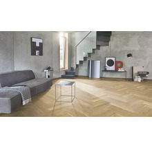 Salon moderne avec parquet en chevrons en bois de chêne, murs en béton apparent gris et escalier au design minimaliste.