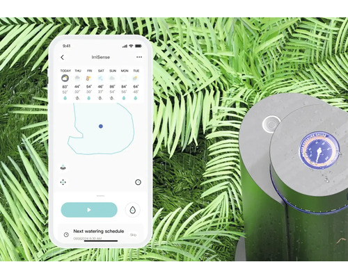 Smartphone mit geöffneter IrriSense-App neben einer Bewässerungsanlage im Garten.