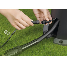 Anschluss eines Gartenstrahlerkabels mit Stecker auf Rasenfläche
