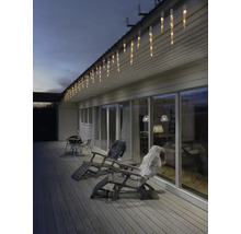 Façade de maison avec guirlande lumineuse glaçons, chaises longues et terrasse pour une ambiance chaleureuse