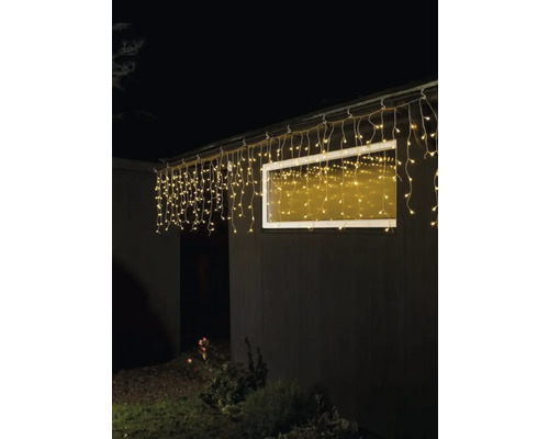 Guirlande lumineuse en forme de glaçons illuminée sur un bâtiment avec fenêtre