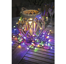 Guirlande lumineuse décorative avec panier en osier et bougie sur une table en bois.
