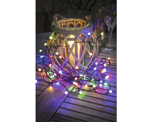 Guirlande lumineuse décorative avec panier en osier et bougie sur une table en bois.