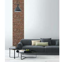 Salon avec canapé gris, tables d''appoint et mur en briques