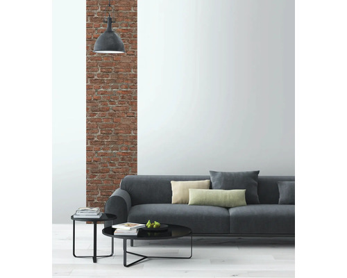 Salon avec canapé gris, tables d''appoint et mur en briques