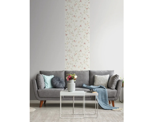 Salon avec canapé gris, table blanche et papier peint à fleurs