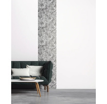 Salon avec canapé vert foncé, table basse et papier peint à motifs floraux