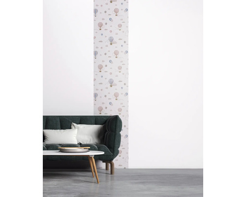 Salon avec papier peint à motifs de montgolfières, canapé et table