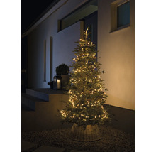Arbre de Noël illuminé dans un panier à l''extérieur.