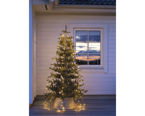 Sapin de Noël décoratif avec guirlande lumineuse à l''extérieur devant une fenêtre