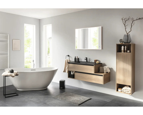 Helles Badezimmer mit Badewanne, Waschtisch, Spiegel und Schrank für ein organisiertes Ambiente.