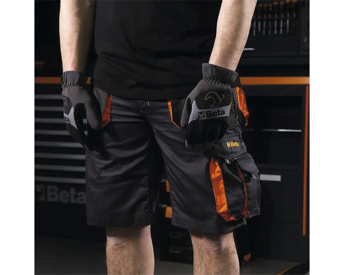 Personne portant un pantalon de travail et des gants de travail de la marque Beta