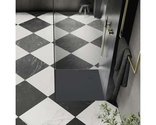 Salle de bain avec cabine de douche, serviette et carrelage à motif en damier