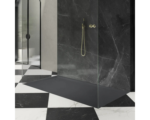 Duschbereich mit Duschwanne, Duscharmatur und Duschabtrennung vor schwarzer Marmorwand